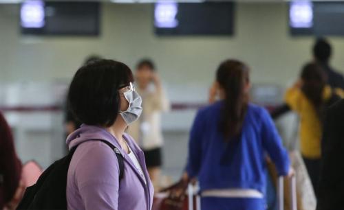 首爾金浦國際機場內的乘客們戴著口罩